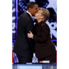 Obama le comenta a Clinton al oído algún tema al final del cara a cara