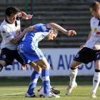 Javi Navarro pugna por el balón entre dos defensas.