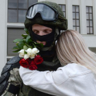 Una mujer abraza en Minsk a un policía en una manifestación de apoyo a la oposición. YAUHEN YERCHAK