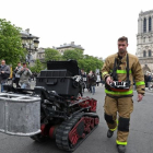 Un bombero, junto con el robot que ayudó a los bomberos en el incendio de Notre Dame, este martes.