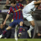 Lionel Messi, a la izquierda, pelea un balón con el defensa portugués del Real Madrid Pepe durante e