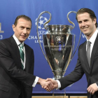 Emilio Butragueño, director de relaciones institucionales del Real Madrid, estrecha la mano al exjugador del Borussia de Dortmund Lars Ricken tras el sorteo.