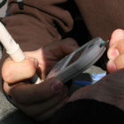 Un paciente realiza una prueba de glucosa tomando una muestra de sangre en el dedo.