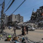 Vecinos de una de las calles de Gaza atacadas por Israel caminan entre los escombros. MOHAMMED SABER