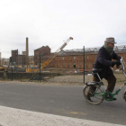 Un ciudadano pasea en bici por delante de las obras del Palacio de Congresos.