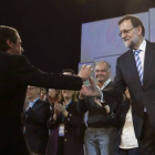 El presidente del Gobierno, Mariano Rajoy, saluda a José María Aznar al finalizar el acto de clausura de la convención nacional del PP.