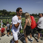 Roger Federer camina entre los aficionados tras entrenarse en las pistas de Wimbledon