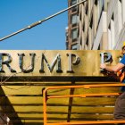 Un obrero retira el nombre de Trump Place en la fachada de un complejo de apartamentos. A. VIGARAY