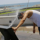 Un hombre se moja en plena ola de calor.