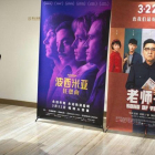 Un cliente de un cine chino observa un cartel de la película Bohemian Rhapsody en Pekín.