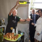 El leonés Carral escancia sidra ante Silvia Clemente en la Feria Internacional Agropecuaria.