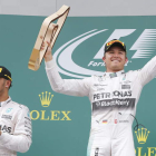 Mercedes mantiene su dominio absoluto: Rosberg levanta el trofeo y Hamilton le aplaude.