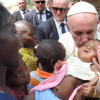 El papa besa a un niño en un campo de refugiados.