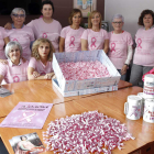 Las mujeres de Almom, ayer,  preparan los lazos, camisetas, globos y las  bolsas que se repartirán el domingo en la carrera.