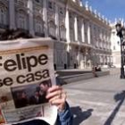 Una persona lee un diario con la ya famosa noticia delante del Palacio de Oriente