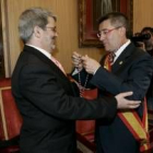 Agustín Mariano Pérez Lamo, el número 13, sonríe mientras el alcalde le coloca la medalla de edil