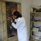 Luisa Castillo trabaja en la restauración de una tabla del retablo