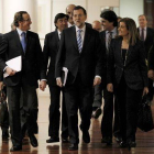 Rajoy acude a la reunión a puerta cerrada con sus diputados en el Congreso, acompañado de varios ministros y colaboradores, ayer.