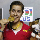 Carolina Marín 'muerde' la medalla de oro que la acredita como ganadora del Abierto de Malasia de bádminton.