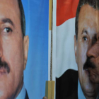 Un yemení besa un cartel con el retrato del presidente, Alí Abdalá Saleh.