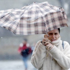 Una mujre se protege de la lluvia y el viento con un paraguas. LAVANDEIRA JR