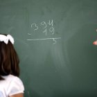 Una niña escucha las instrucciones de su profesora.