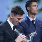 Leo Messi con su trofeo al mejor jugador de la Uefa sonríe con Cristiano de fondo