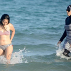 Una mujer con biquini y otra con 'burkini' en la playa tunecina de Ghar El Melh.
