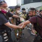Fotoperiodistas se limpian con agua el gas lacrimógeno utilizado durante las protestas.