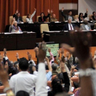 Diputados de la Asamblea Nacional de Cuba ejercen su derecho al voto durante la sesion plenaria celebrada el 22 de diciembre en el Parlamento, en La Habana.