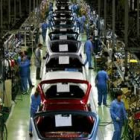 Imagen de unos trabajadores en la cadena de producción de automóviles