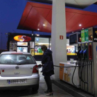 Una mujer repostando en una gasolinera.