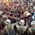 Soldados británicos contienen a una multitud que intenta alcanzar los camiones de ayuda en Az Zubaya