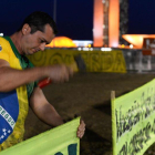 Un partidario de Rousseff clava un cartel en las afueras del senado brasileño.