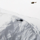 Dos helicópteros patrullan sobre los Alpes franceses durante un rescate.