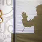 La silueta del candidato de CiU, Artur Mas, reflejada en un panel durante un mitin.