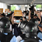 Un grupo de manifestantes sostienen pancartas de protesta contra la policía hongkonesa, este jueves.