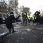 Un estudiante blande un palo ante antidisturbios británicos.