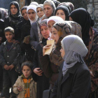 Mujeres de Yarmuk esperan la entrega de ayuda humanitaria.