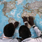 Dos personas inmigrantes localizan en el mapa su lugar de procedencia. EFE