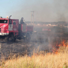 Bomberos sofocando un incendio, este verano, desde el vial de acceso de Trobajo a la LE-30.
