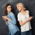 Una chica espía el móvil de su amiga.