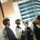 Un ciudadano protesta ante un cordón policial frente a la comisaría de Ferguson, este miércoles.