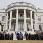 Obama, su esposa Michelle y empleados de la Casa Blanca guardan un minuto de silencio.