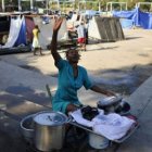 Una mujer lava instrumentos de cocina en un albergue en Puerto Principe.