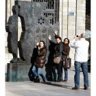 Unos turistas en el monumento de la Plaza de la Catedral.