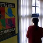 Una mujer mira por la ventana en las oficinas de la Asociación de Víctimas de Malos Tratos, Adavas