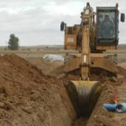 Una excavadora trabaja en la modernización de los regadíos en la zona de Los Oteros