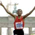 Gebrselassie levanta los brazos tras cruzar la meta en la capital alemana