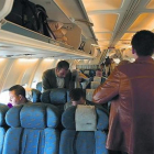 Varios pasajeros se acomodan en un avión del puente aéreo.